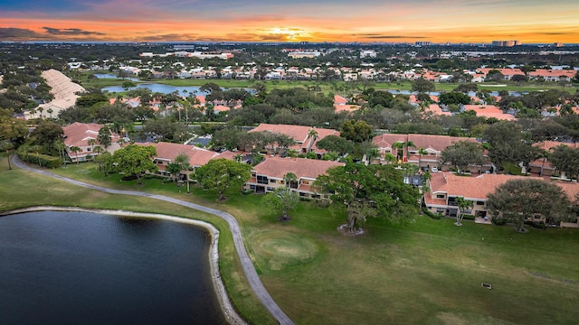 aerial view at dusk featuring a water view