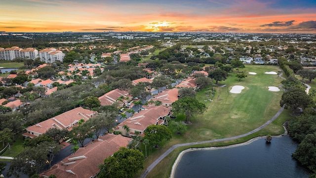 aerial view at dusk featuring a water view