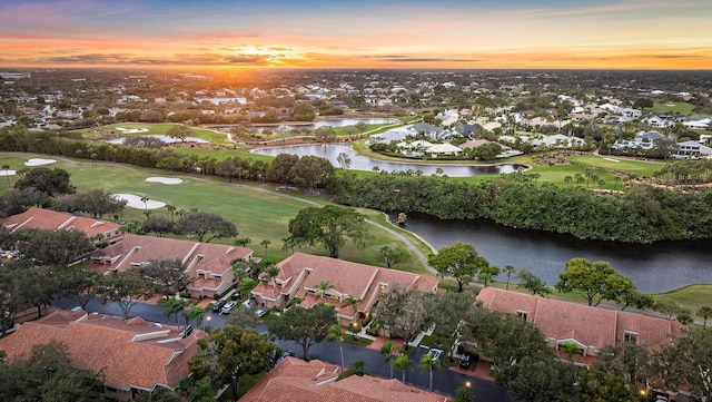 aerial view at dusk featuring a water view