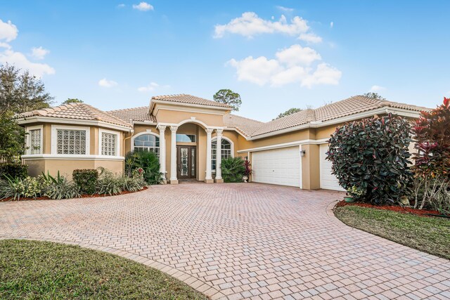 view of front of house with a lanai, a garage, and a front lawn