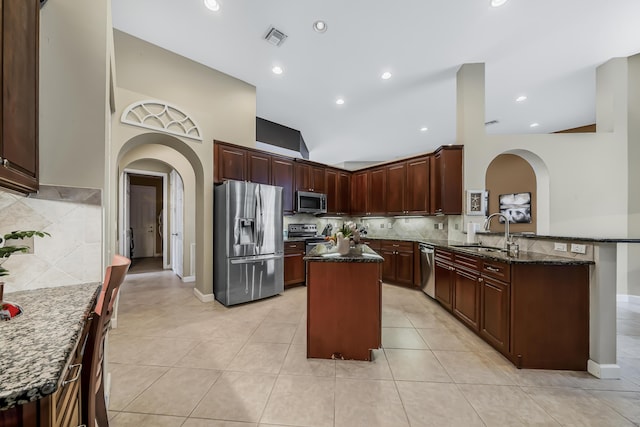 kitchen featuring arched walkways, stainless steel appliances, a sink, and visible vents