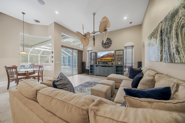 living area featuring a healthy amount of sunlight, a sunroom, visible vents, and light tile patterned flooring