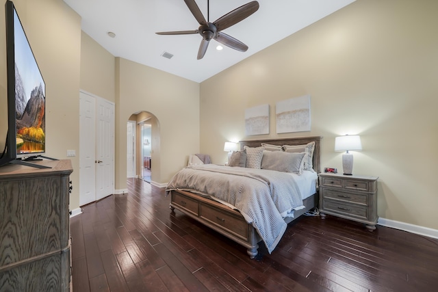 bedroom featuring arched walkways, dark wood-style flooring, a ceiling fan, visible vents, and baseboards