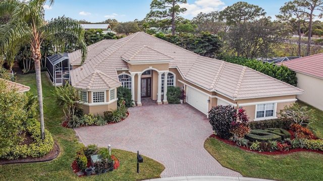 view of front of home with a garage, a tiled roof, decorative driveway, and stucco siding