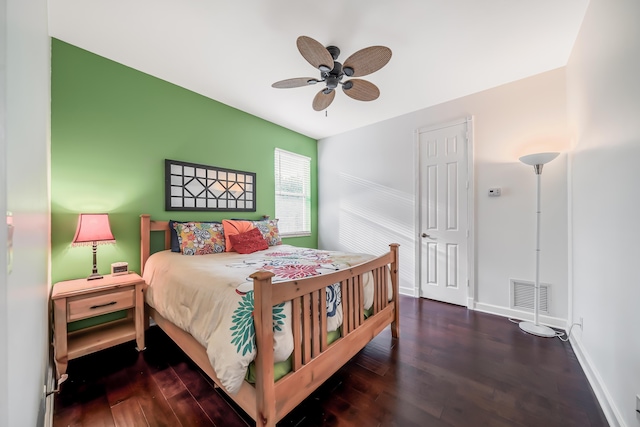 bedroom with a ceiling fan, wood finished floors, visible vents, and baseboards