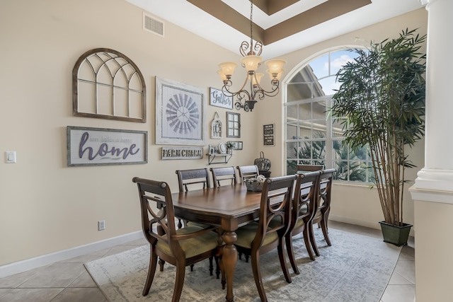 tiled dining area with an inviting chandelier, decorative columns, visible vents, and baseboards