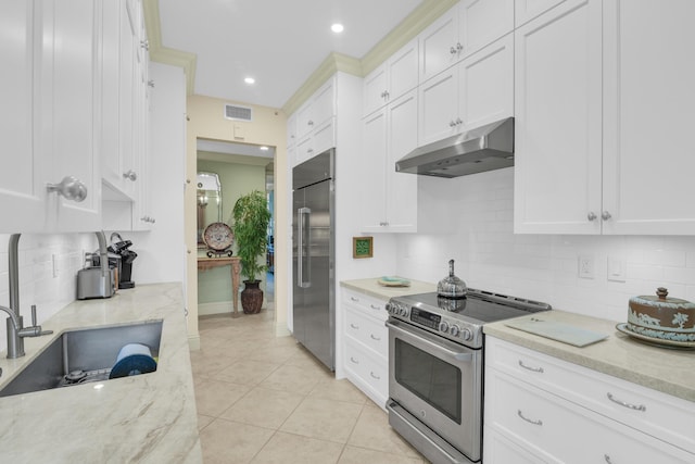 kitchen featuring light stone countertops, sink, light tile patterned floors, white cabinets, and appliances with stainless steel finishes