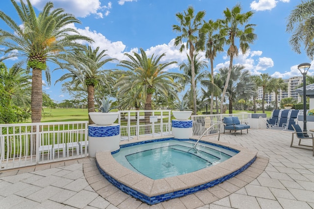 view of pool with a patio and a hot tub