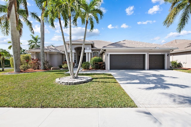 mediterranean / spanish home featuring a front lawn and a garage