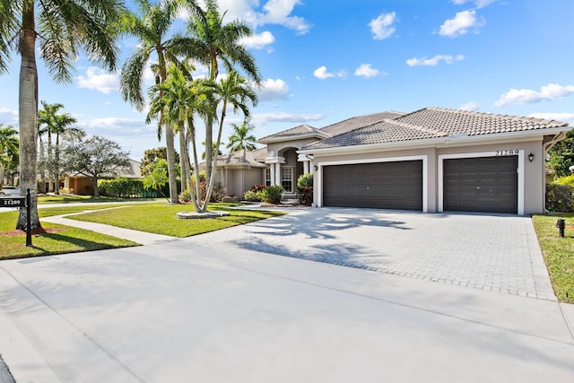 mediterranean / spanish-style home featuring a garage and a front lawn