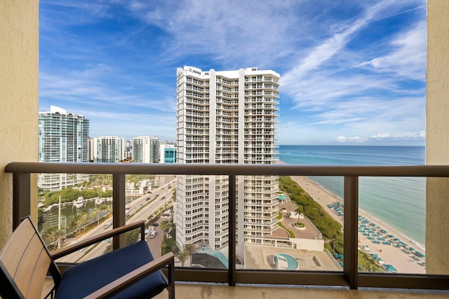 balcony featuring a view of the beach and a water view