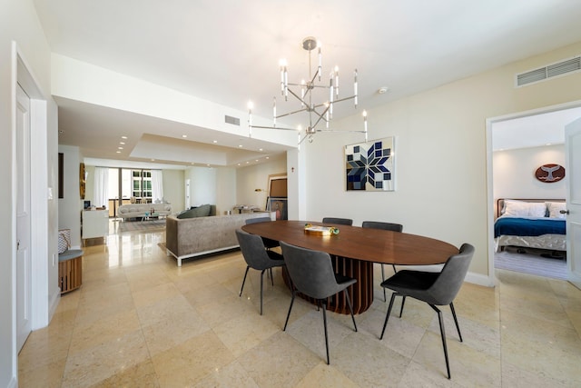 dining room with a notable chandelier and a tray ceiling