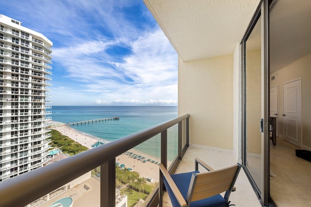 balcony featuring a water view and a beach view