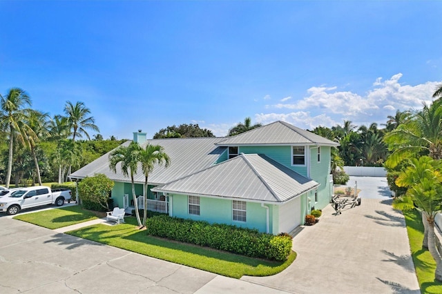 view of property featuring a garage and a front lawn