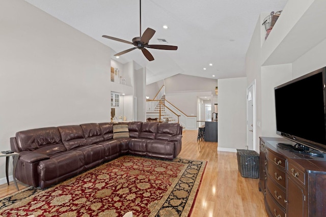 living room with ceiling fan, high vaulted ceiling, and light hardwood / wood-style flooring