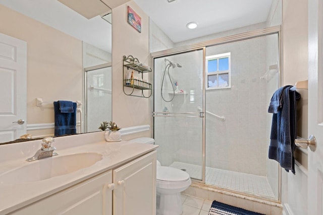 bathroom with tile patterned floors, vanity, toilet, and a shower with shower door