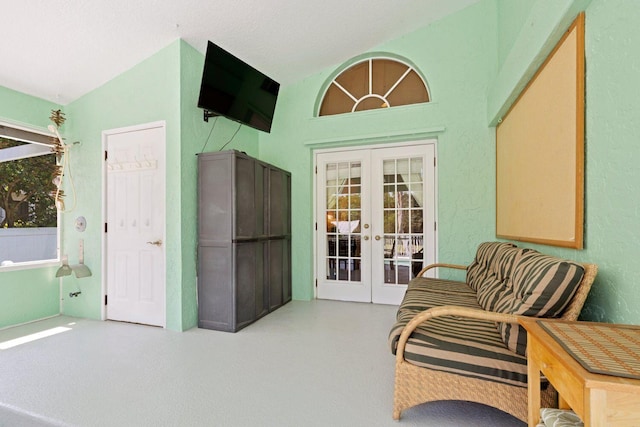 sitting room with french doors and lofted ceiling