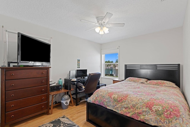 bedroom with a textured ceiling, light hardwood / wood-style floors, and ceiling fan