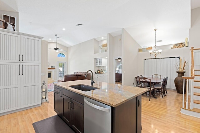 kitchen featuring sink, stainless steel dishwasher, an island with sink, decorative light fixtures, and ceiling fan with notable chandelier