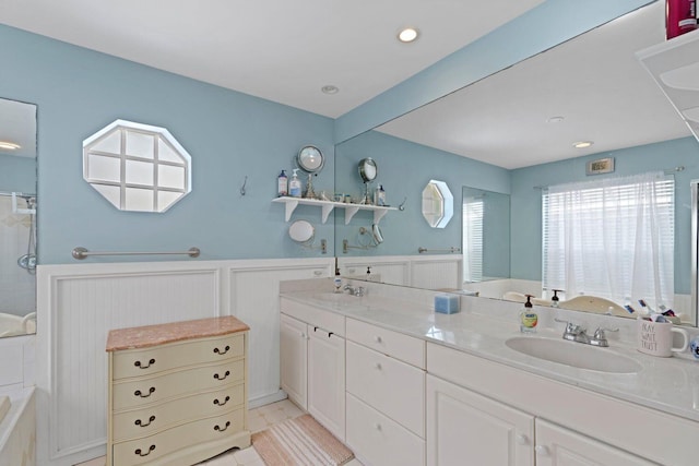 bathroom featuring tile patterned flooring, vanity, and a relaxing tiled tub