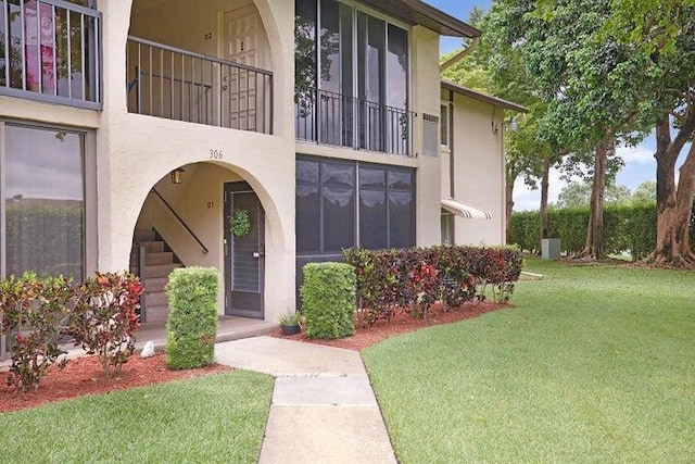 property entrance with a lawn