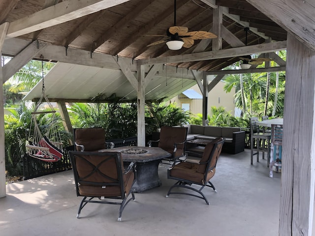 view of patio with a gazebo, ceiling fan, and an outdoor living space with a fire pit