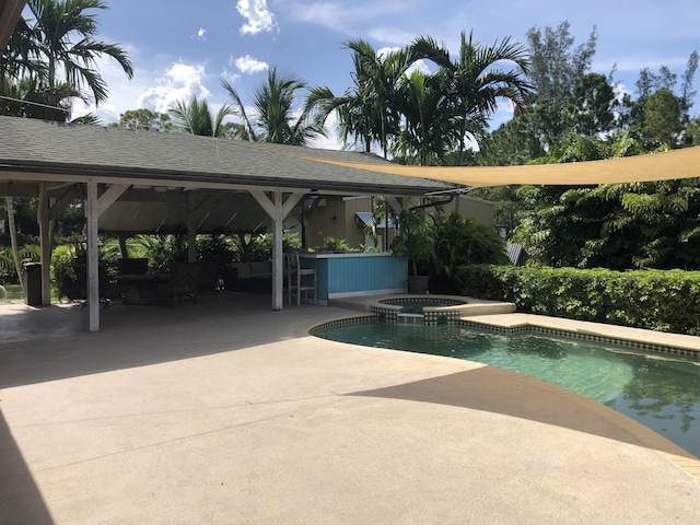 view of swimming pool featuring exterior bar, a gazebo, an in ground hot tub, and a patio area