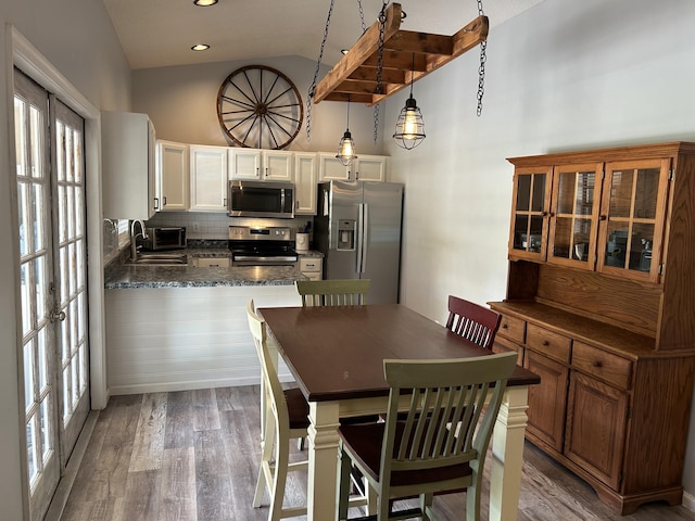 kitchen featuring lofted ceiling, french doors, a kitchen breakfast bar, sink, and appliances with stainless steel finishes