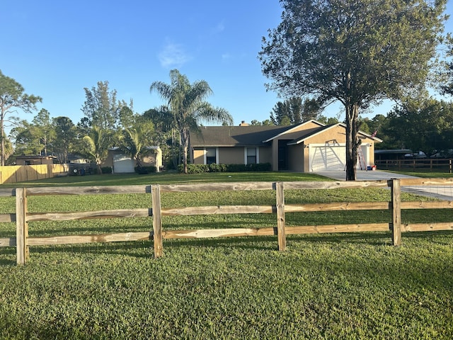 view of front of property featuring a rural view, a garage, and a front yard