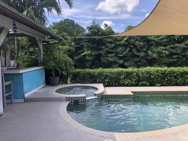 view of swimming pool featuring an in ground hot tub