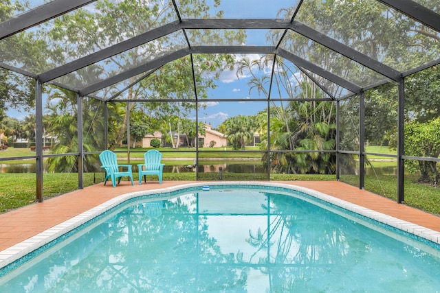 outdoor pool featuring a patio area, glass enclosure, and a water view