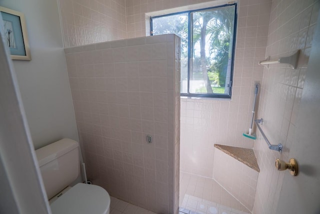 bathroom with toilet and a tile shower