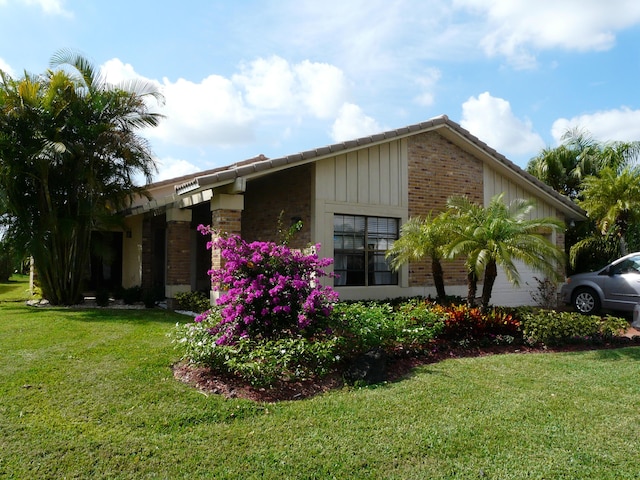 view of side of home with a yard and a garage