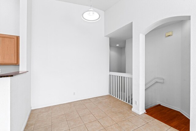 empty room featuring ceiling fan, light hardwood / wood-style flooring, a healthy amount of sunlight, and lofted ceiling