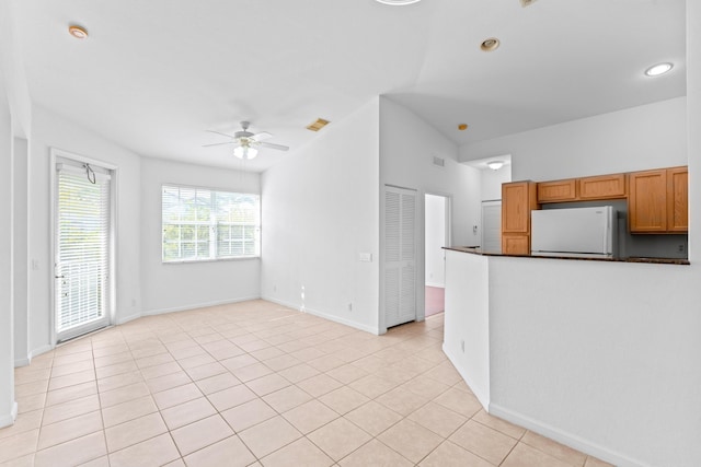 kitchen featuring ceiling fan, light tile patterned flooring, and white refrigerator