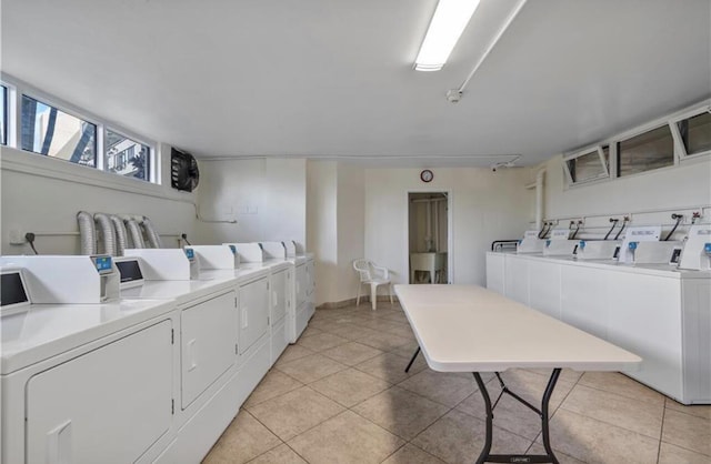 clothes washing area featuring light tile patterned flooring and washing machine and clothes dryer