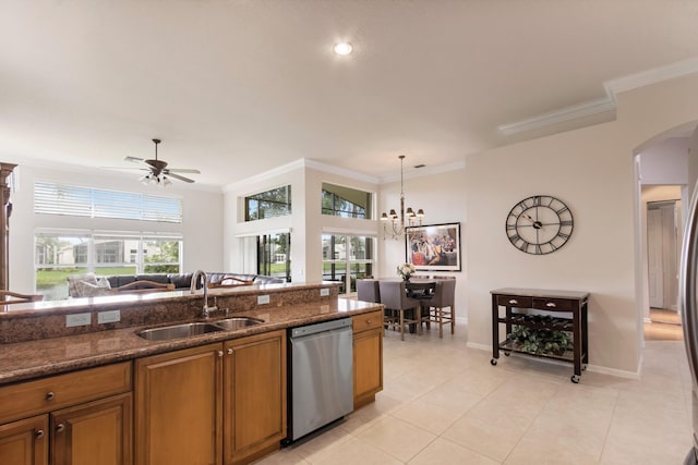 kitchen featuring dark stone counters, ceiling fan with notable chandelier, sink, stainless steel dishwasher, and decorative light fixtures