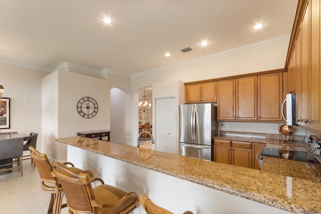 kitchen featuring kitchen peninsula, light stone countertops, stainless steel appliances, crown molding, and an inviting chandelier