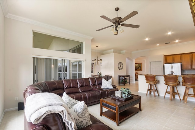 tiled living room featuring ceiling fan with notable chandelier and ornamental molding