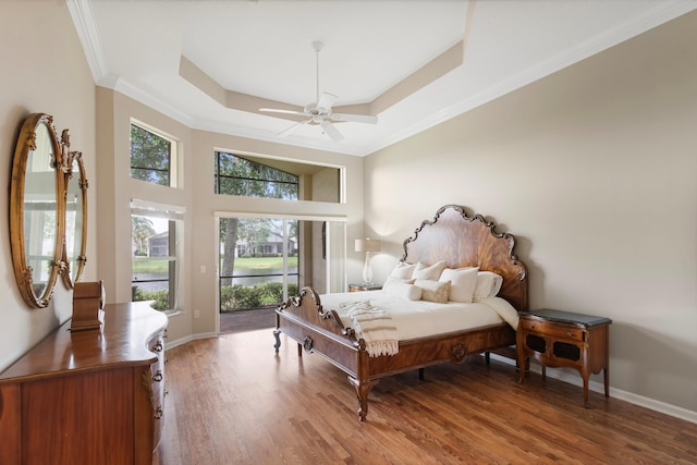 bedroom featuring a tray ceiling, ceiling fan, hardwood / wood-style floors, and crown molding