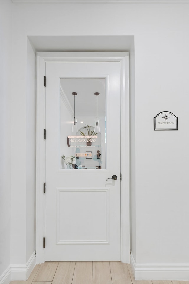 doorway to outside with tile patterned flooring and ornamental molding