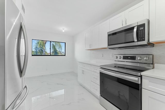 kitchen with white cabinets, stainless steel appliances, and tasteful backsplash