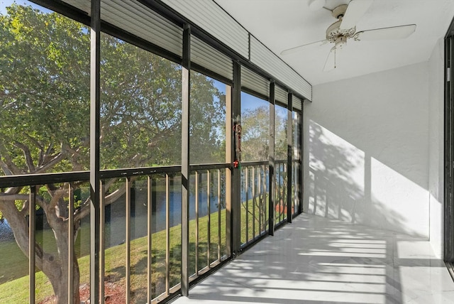 unfurnished sunroom with a water view and ceiling fan