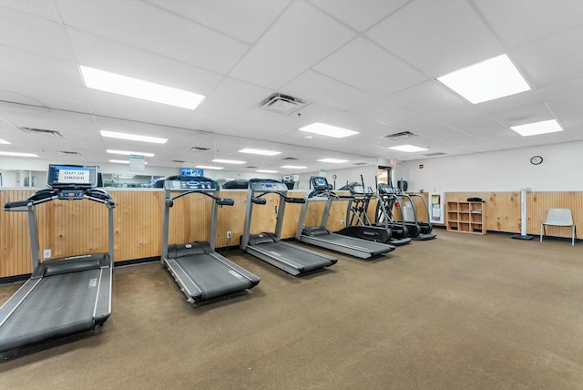 gym featuring a drop ceiling and dark carpet