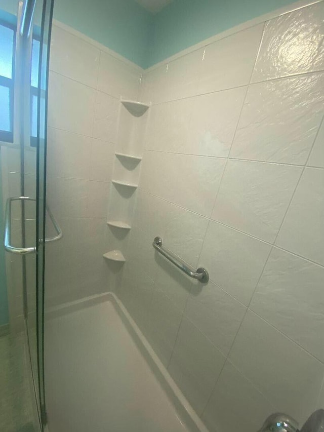 bathroom featuring a shower with shower door