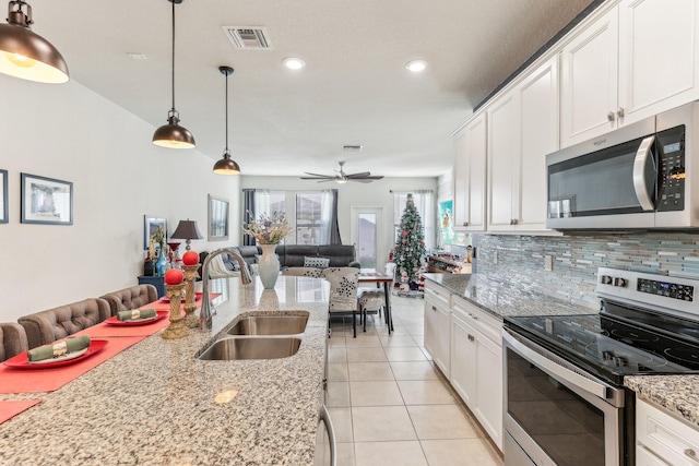 kitchen featuring pendant lighting, stainless steel appliances, white cabinetry, and sink