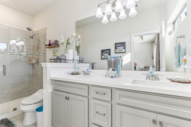 bathroom featuring tile patterned flooring, vanity, toilet, and a shower with door