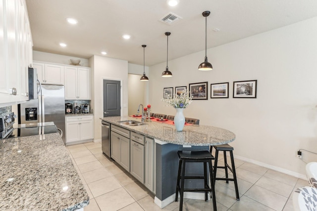 kitchen featuring a center island with sink, white cabinets, sink, and appliances with stainless steel finishes