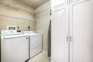 washroom featuring washing machine and dryer and cabinets