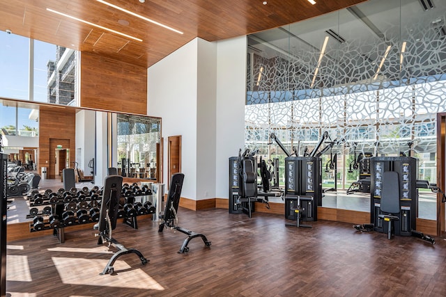 workout area featuring wood-type flooring, wooden ceiling, plenty of natural light, and a high ceiling